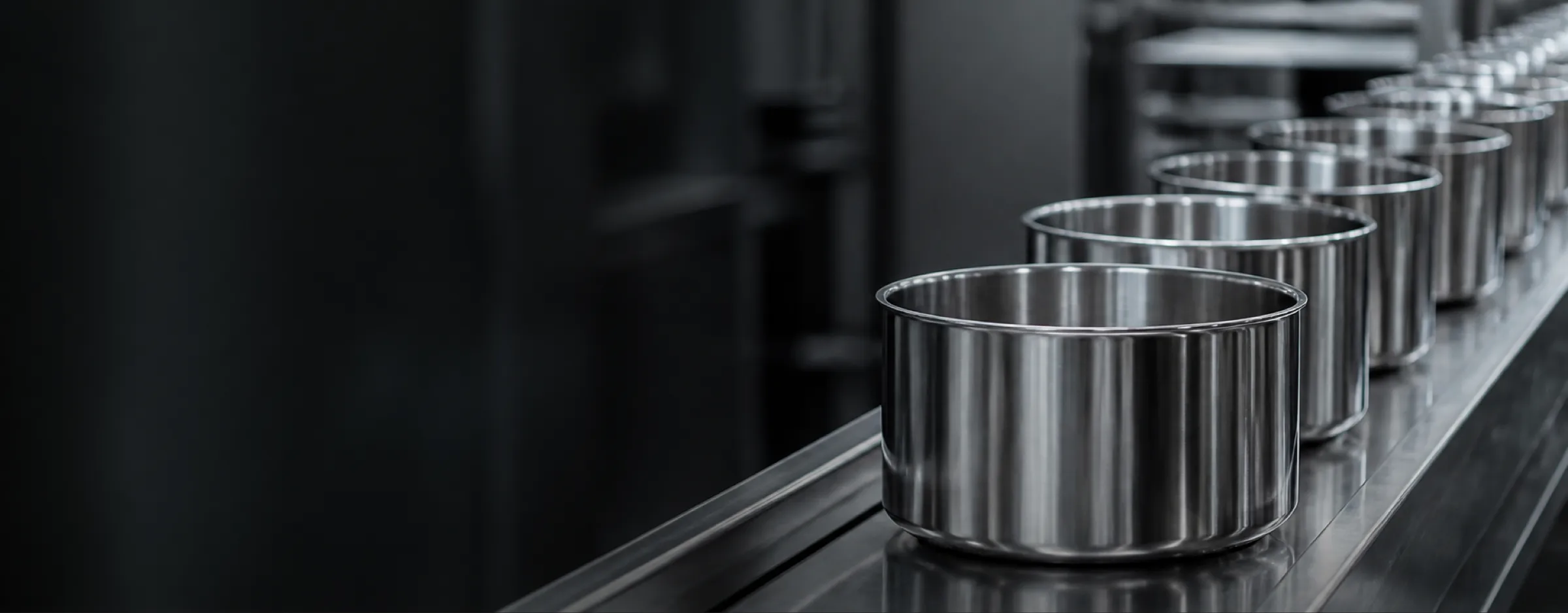 Mirror-polished stainless steel pot bodies travelling down a finishing line
